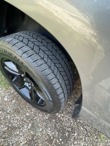 Close-up of Continental TerrainContact H/T tire on SUV, showing detailed tread design with stable center ribs for a smooth and quiet ride.