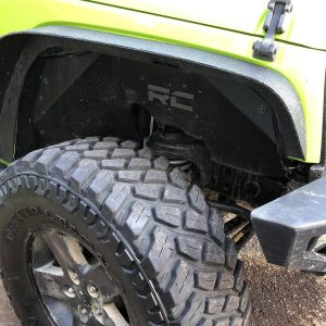 Firestone Destination M/T tire mounted on a Jeep Wrangler showing deep tread blocks and aggressive shoulder lugs for superior mud traction.
