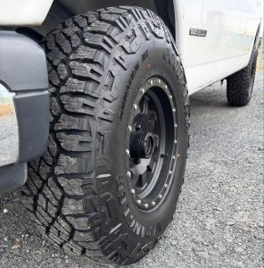 Close-up of Goodyear Wrangler Duratrac RT tire on a GMC Sierra, showing aggressive tread and sidewall design built for all-terrain performance and winter traction.