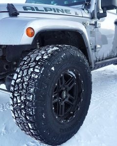 Jeep Wrangler equipped with Nitto Terra Grappler G3 all-terrain tires on snowy terrain, showing tread pattern designed for balanced winter grip and daily driving comfort.