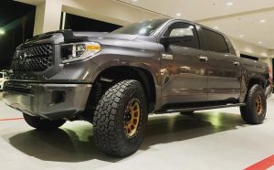 Toyota Tundra equipped with Toyo Open Country A/T III all-terrain tires, showcasing aggressive tread blocks and off-road-ready stance under night lighting.
