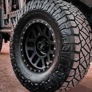 Close-up of Nitto Ridge Grappler tire showcasing its hybrid tread pattern, deep voids, and reinforced shoulder blocks for rugged off-road performance with on-road comfort.