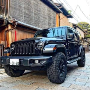 Yokohama Geolandar X-AT tires on a Jeep Wrangler, highlighting aggressive tread blocks and dual sidewall design for both city driving and off-road traction.