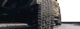 Low-angle view of a truck fitted with Nitto Terra Grappler G3 all-terrain tires, showing snow-packed tread blocks on a winter road for improved traction.