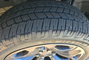 Close-up of Michelin Defender LTX M/S2 tire tread showing symmetric block pattern and siping for wet grip and durability on light trucks and SUVs.